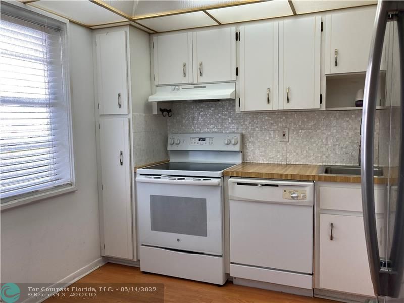 3541 Inverrary Drive, Unit 103 Lauderhill, FL 33319 - Photo 5 of 18 a kitchen with white cabinets and white appliances