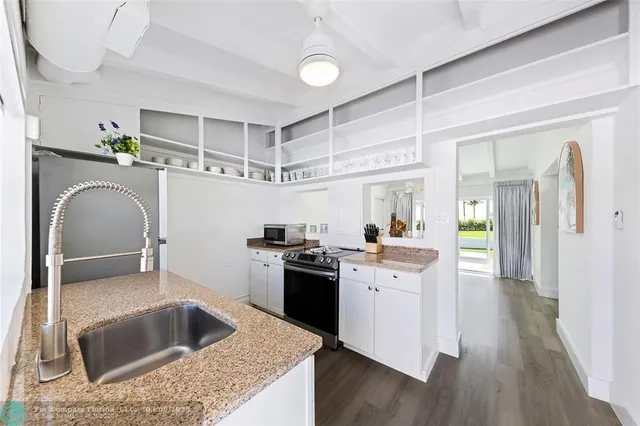 a kitchen with sink cabinets and wooden floor