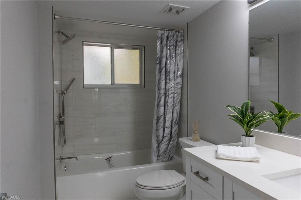 8234 Key Royal Circle, Unit 523 Naples, FL 34119 - Photo 11 of 20 a bathroom with a sink a toilet a tub and shower