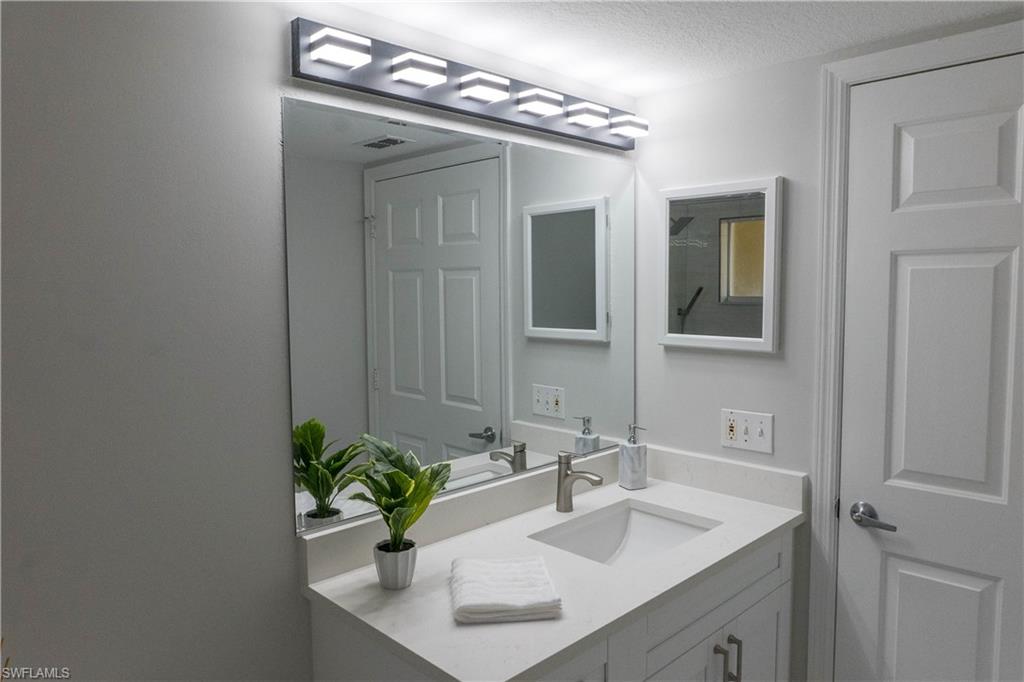 8234 Key Royal Circle, Unit 523 Naples, FL 34119 - Photo 13 of 20 a bathroom with a sink and a mirror