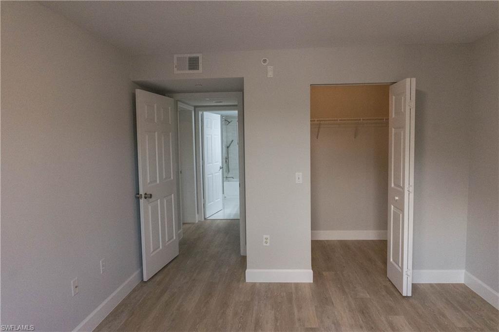8234 Key Royal Circle, Unit 523 Naples, FL 34119 - Photo 16 of 20 a view of a hallway with wooden floor