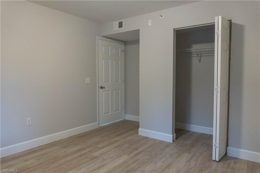8234 Key Royal Circle, Unit 523 Naples, FL 34119 - Photo 19 of 20 a view of an empty room with wooden floor