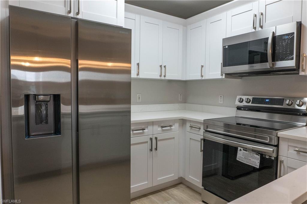 8234 Key Royal Circle, Unit 523 Naples, FL 34119 - Photo 3 of 20 a kitchen with a refrigerator stove and microwave