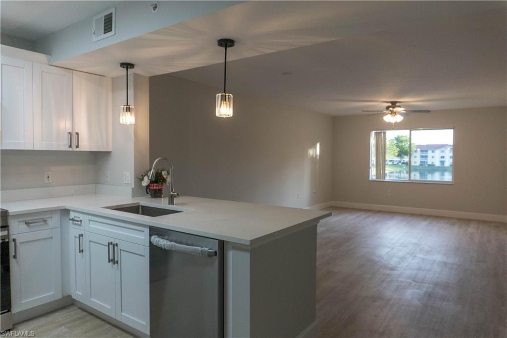 8234 Key Royal Circle, Unit 523 Naples, FL 34119 - Photo 4 of 20 a kitchen with a sink stove and cabinets