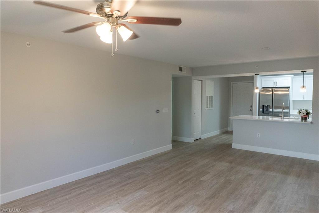 8234 Key Royal Circle, Unit 523 Naples, FL 34119 - Photo 7 of 20 wooden floor in an empty room with a window