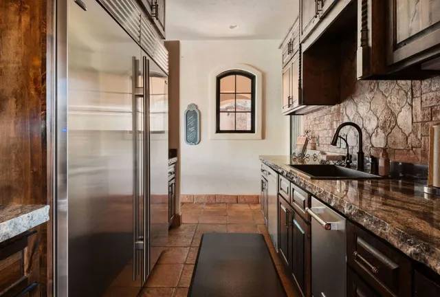 a kitchen with stainless steel appliances granite countertop a sink stove and refrigerator