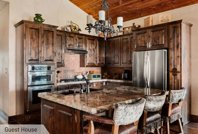 a kitchen with stainless steel appliances granite countertop a sink refrigerator and cabinets