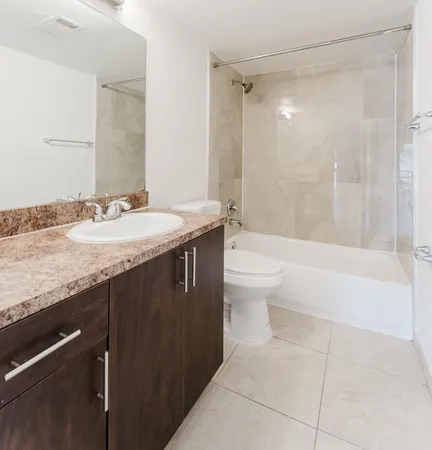a bathroom with a granite countertop sink a toilet and shower