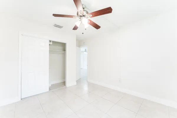 an empty room with a ceiling fan and a window