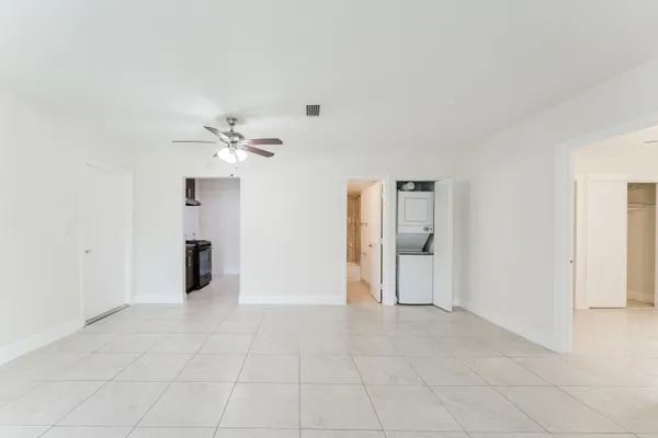a view of an empty room with a chandelier fan