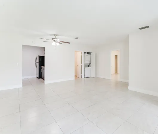 an empty room with a bathroom and a ceiling fan