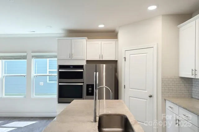 a kitchen with stainless steel appliances wooden cabinets and a refrigerator