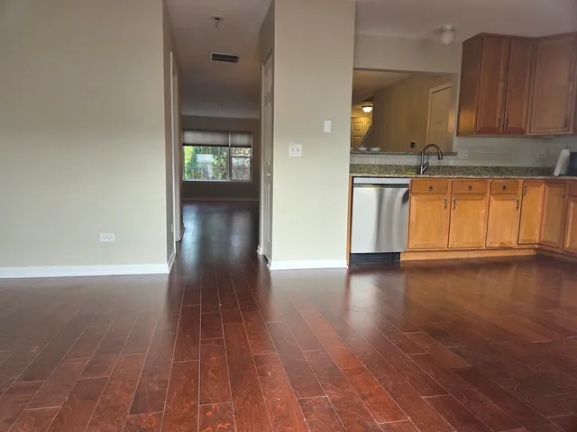 a view of a kitchen with wooden floor and a window