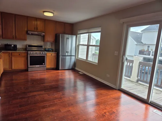 a kitchen with granite countertop wooden floors and stainless steel appliances
