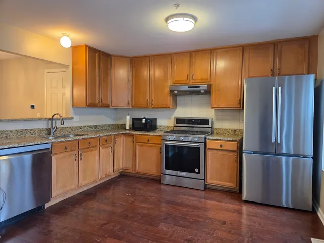 a kitchen with granite countertop stainless steel appliances and wooden cabinets