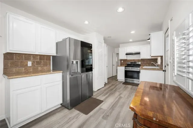 a kitchen with stainless steel appliances granite countertop a sink stove and cabinets