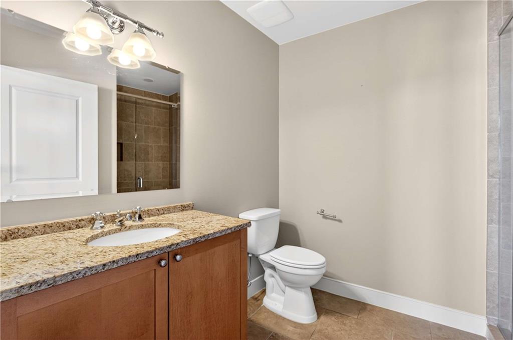 201 West Ponce De Leon Avenue, Unit 702 Decatur, GA 30030 - Photo 24 of 41 a bathroom with a granite countertop sink toilet and a mirror