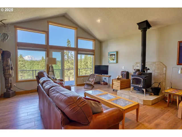 a living room with furniture a flat screen tv and a large window