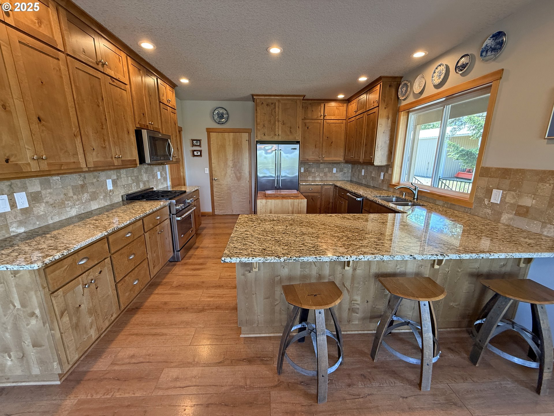 12 Keystone Drive Goldendale, WA 98620 - Photo 18 of 48 a kitchen with kitchen island granite countertop wooden cabinets and a refrigerator