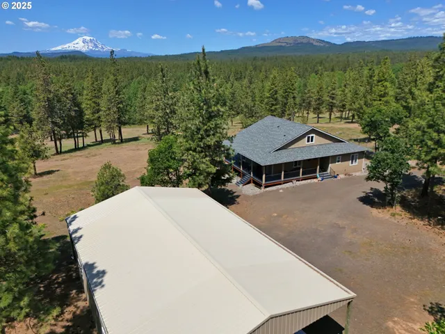 a view of a house with a yard and sitting area
