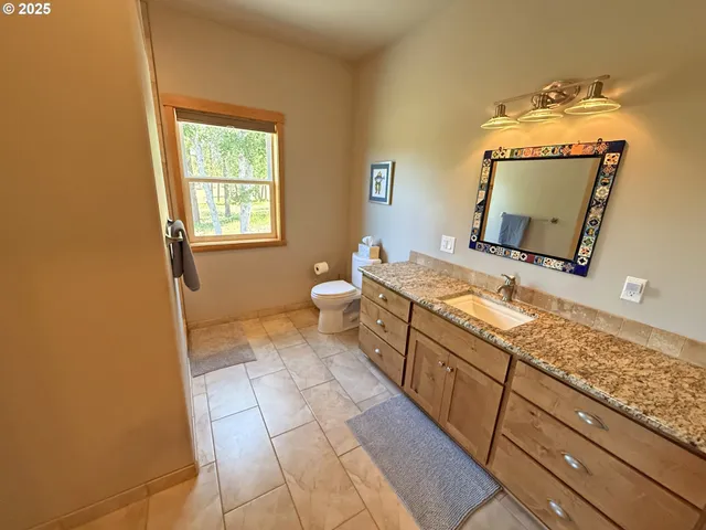 a spacious bathroom with a granite countertop sink and a mirror
