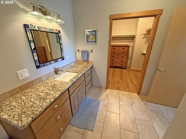 a bathroom with a granite countertop sink and a mirror