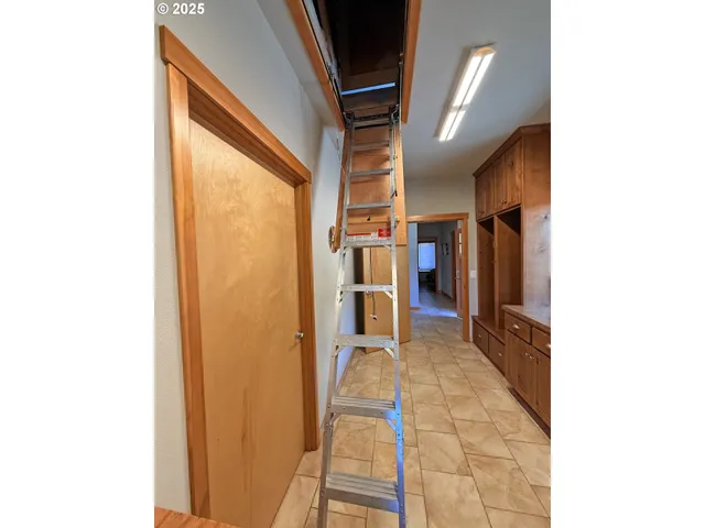 a view of a hallway with wooden floor and a bathroom