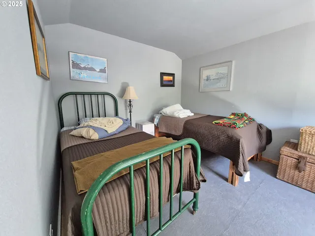 a bedroom with two beds and a desk