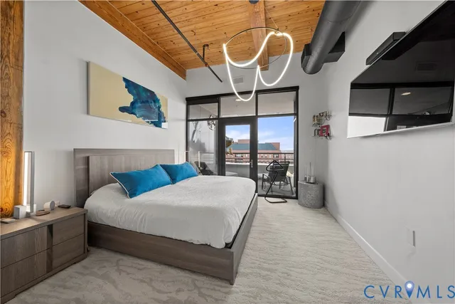 a bedroom with a bed a flat screen tv and view of bathroom