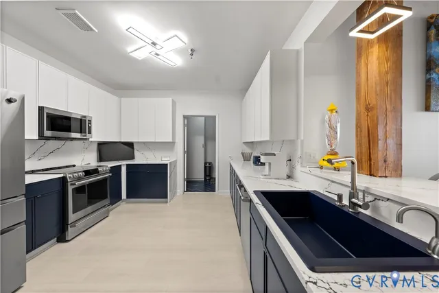 a kitchen with stainless steel appliances a stove refrigerator sink and microwave