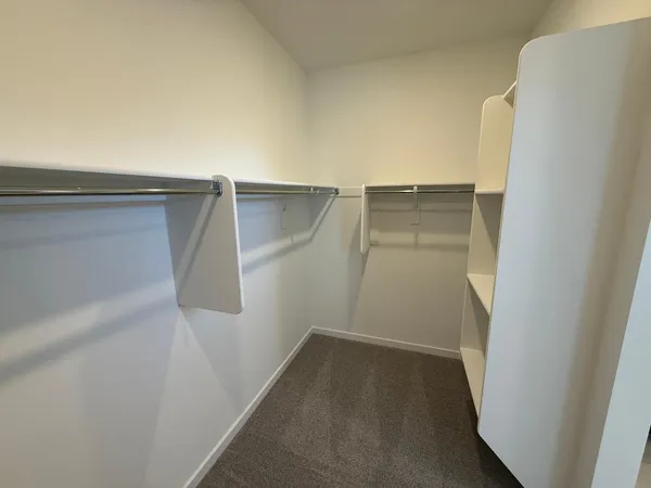 a view of walk in closet with empty racks