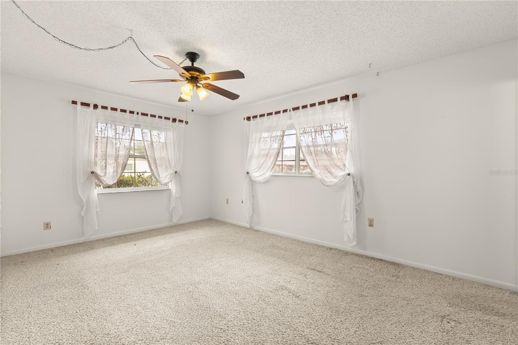 15218 Southwest 43rd Terrace Road Ocala, FL 34473 - Photo 18 of 30 an empty room with windows and fan