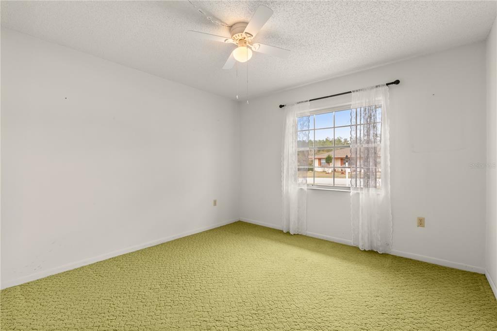 15218 Southwest 43rd Terrace Road Ocala, FL 34473 - Photo 22 of 30 an empty room with a window and a ceiling fan