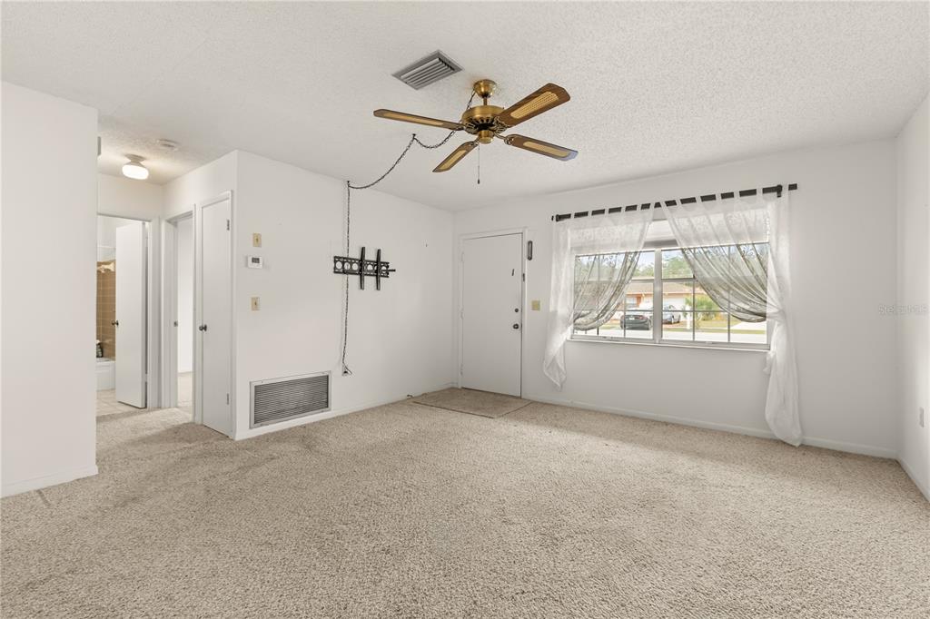 15218 Southwest 43rd Terrace Road Ocala, FL 34473 - Photo 10 of 30 a view of a livingroom with a ceiling fan & windows