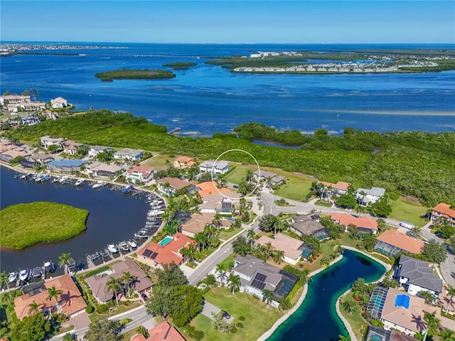 an aerial view of ocean and residential houses with outdoor space
