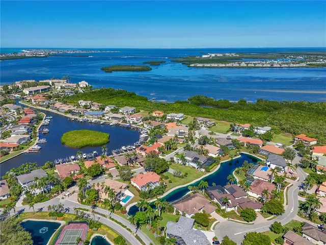 an aerial view of ocean and residential houses with outdoor space