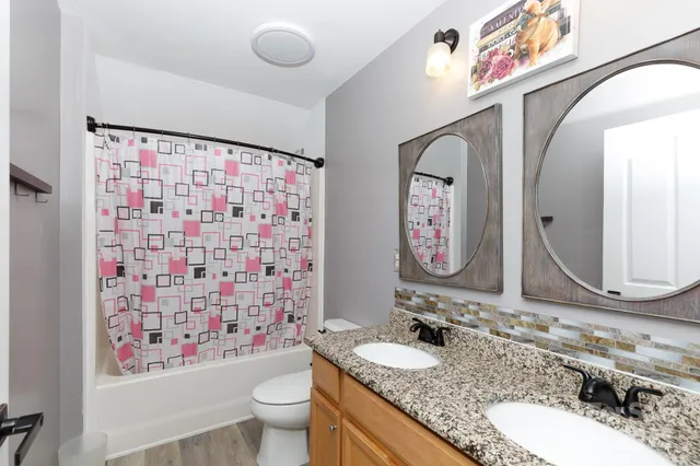 a bathroom with a granite countertop sink mirror vanity and toilet