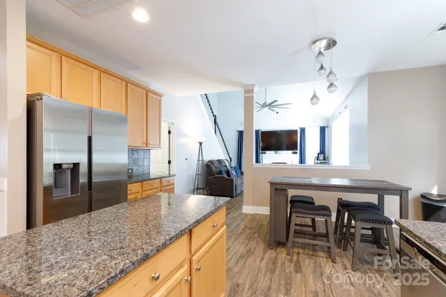 a kitchen with stainless steel appliances granite countertop a sink refrigerator and cabinets