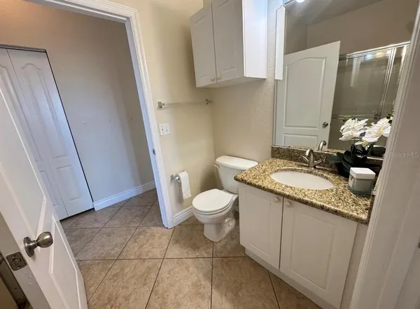 a bathroom with a granite countertop sink toilet and shower