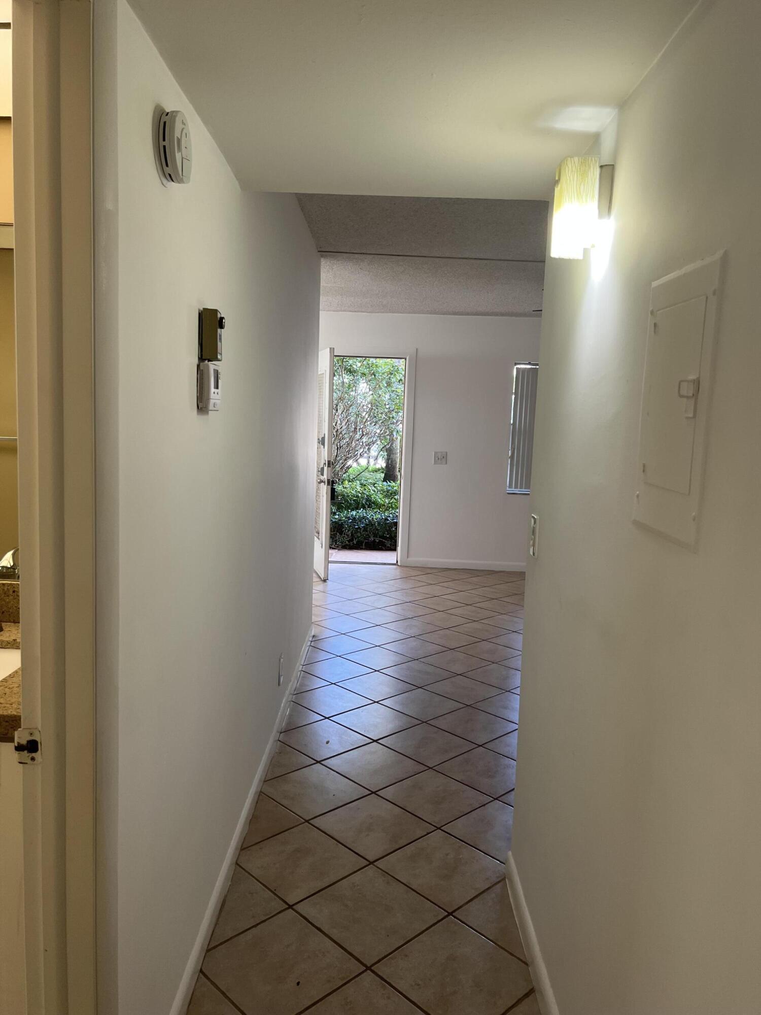 886 Flanders South Delray Beach, FL 33484 - Photo 19 of 41 a view of a hallway with wooden floor and a bathroom
