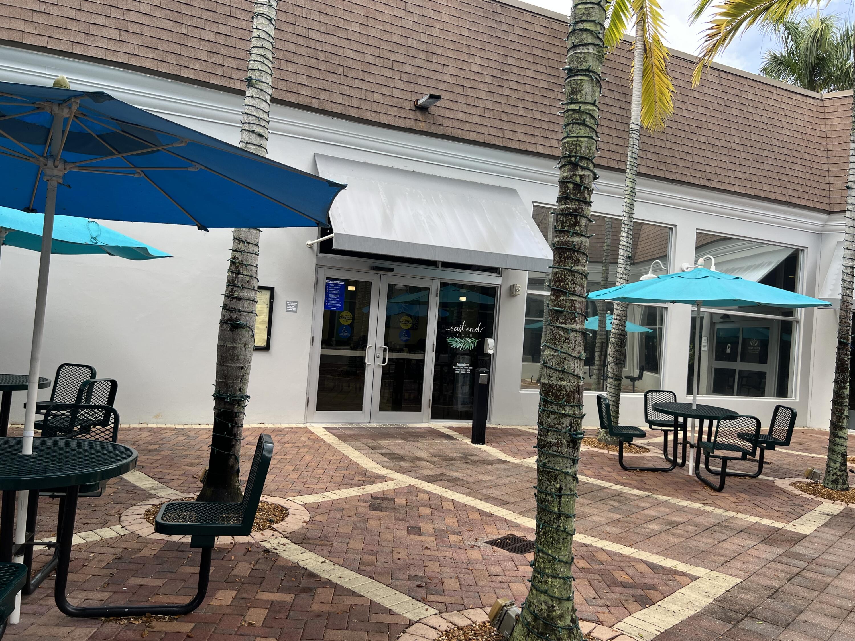886 Flanders South Delray Beach, FL 33484 - Photo 38 of 41 a view of a chairs and table under an umbrella in front of house
