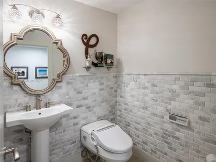 a bathroom with a sink a toilet and mirror