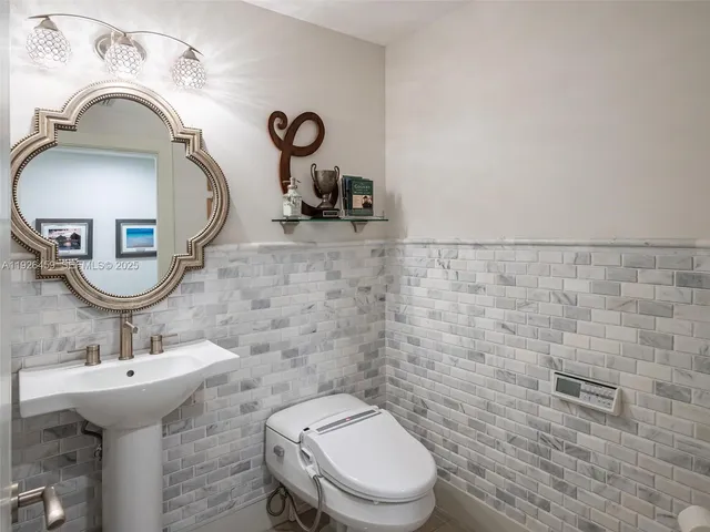 a bathroom with a sink a toilet and mirror