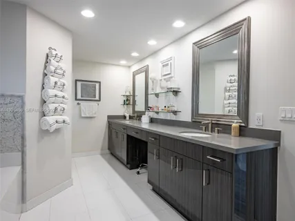 a spacious bathroom with double vanity and a mirror