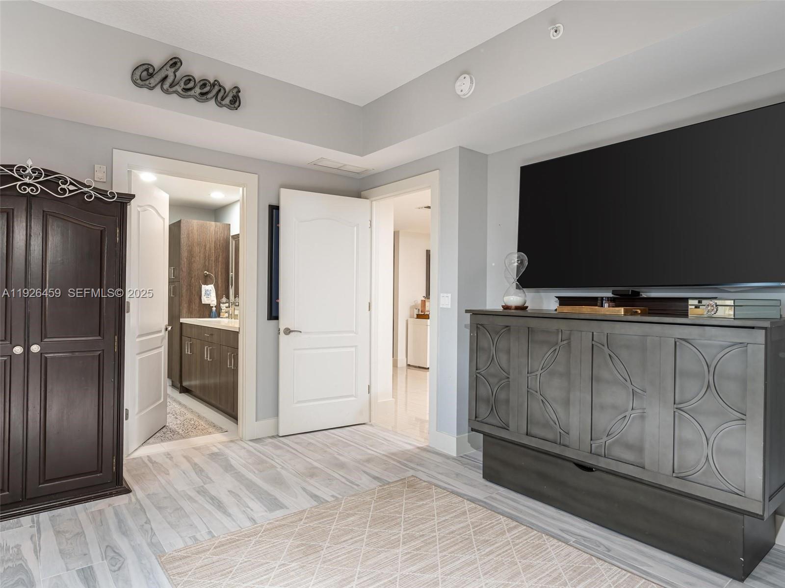 3415 North Ocean Drive, Unit 605 Hollywood, FL 33019 - Photo 19 of 31 a view of a livingroom with wooden floor and a flat screen tv