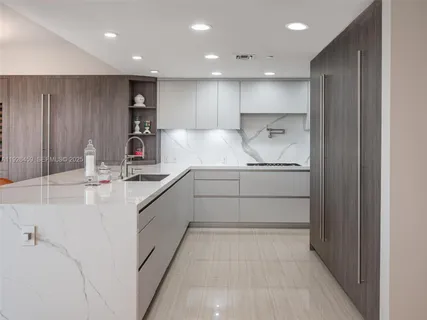 a kitchen with kitchen island white cabinets and stainless steel appliances