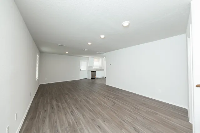 a view of empty room with wooden floor
