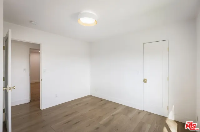 an empty room with wooden floor and closet