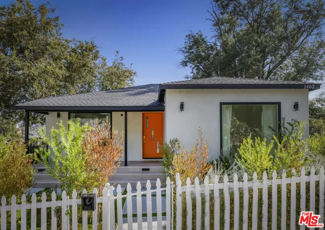 a front view of a house with a garden