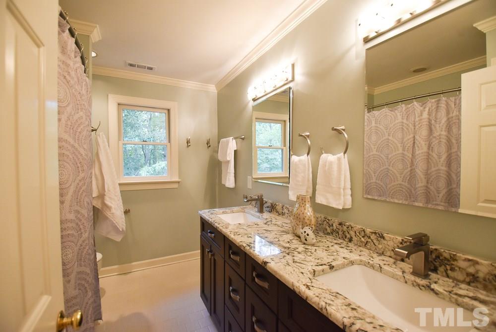 9004 Enfield Court Raleigh, NC 27615 - Photo 22 of 30 The add’l Bedrooms share the spacious hall Bath w/granite vanity, double sinks, neutral tile floor, linen closet, modern light fixture & tiled tub-shower.
